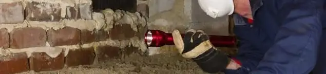Pest control technician inspecting a crawl space for ant activity and entry points in Charlotte, NC